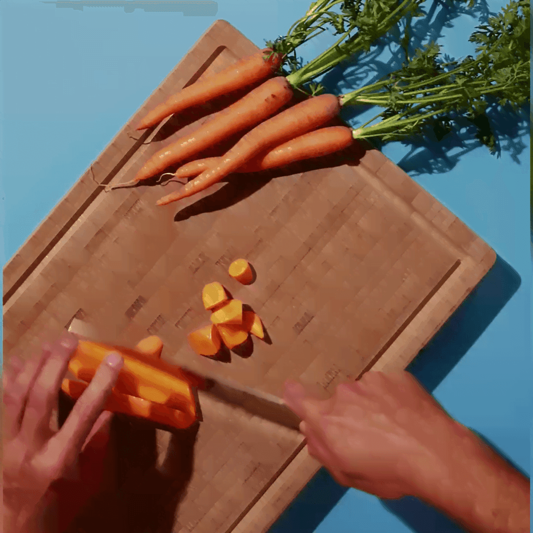 cutting carrots on a woodboard